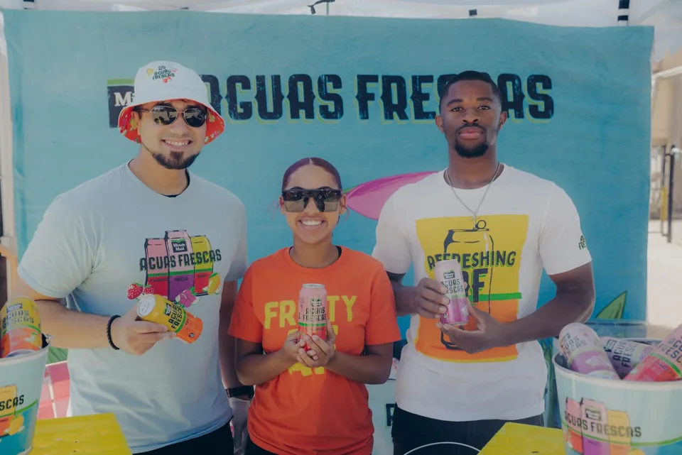 Aguas frescas vendors smiling behind their drink stand