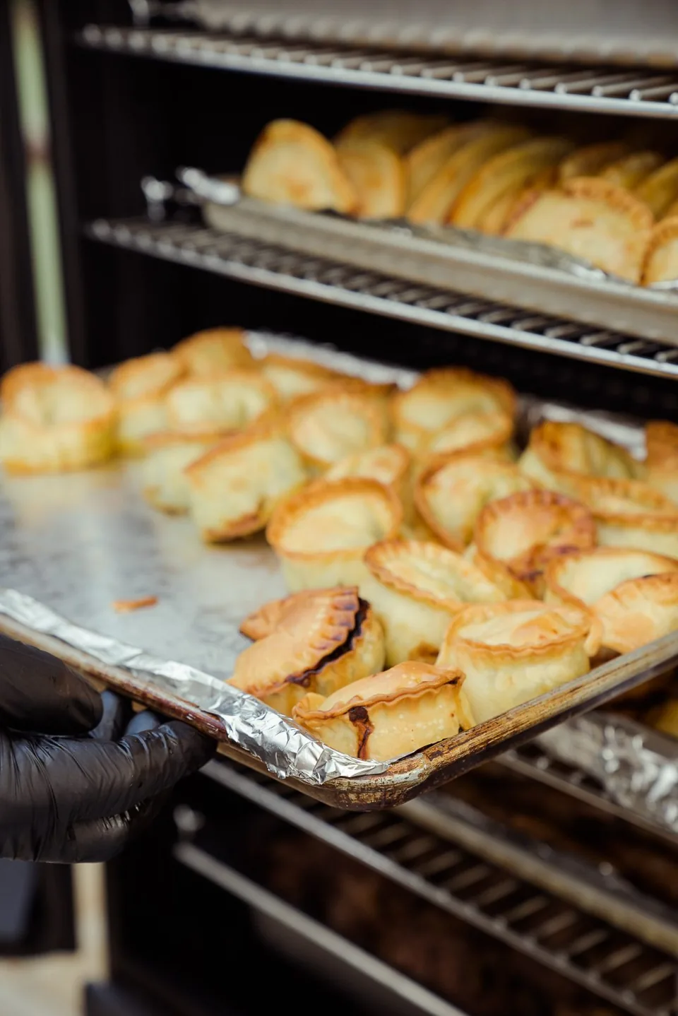 Trays of golden baked empanadas ready to serve