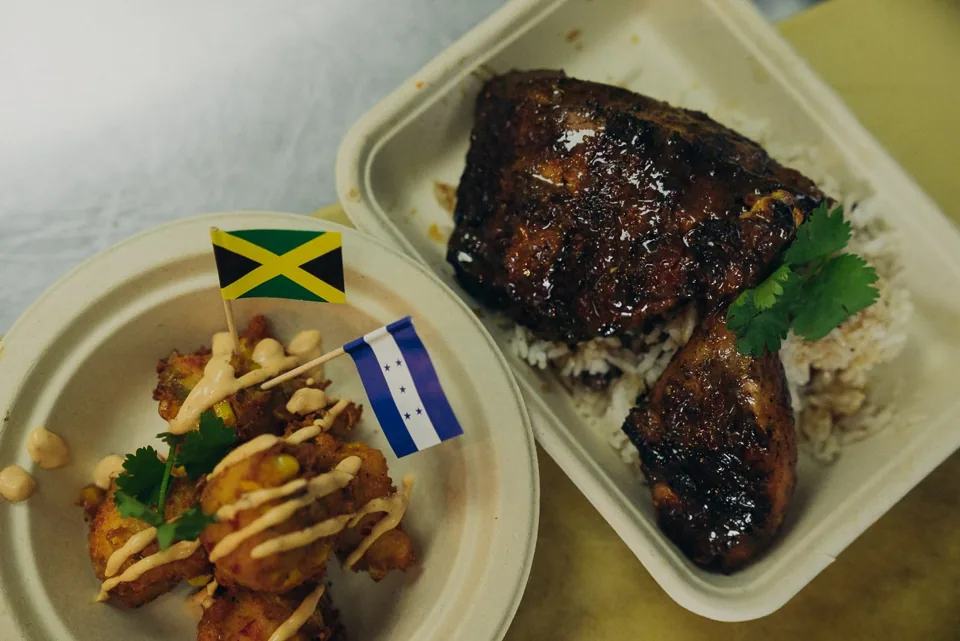 Caribbean food plates with grilled meats and colorful flags
